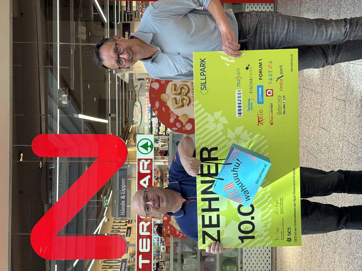 Thomas S. und Markus Siedl (Center-Manager Sillpark, Innsbruck); Herr Siedl überreicht feierlich den 10.000 Euro Scheck und die tatsächlichen Gutscheine